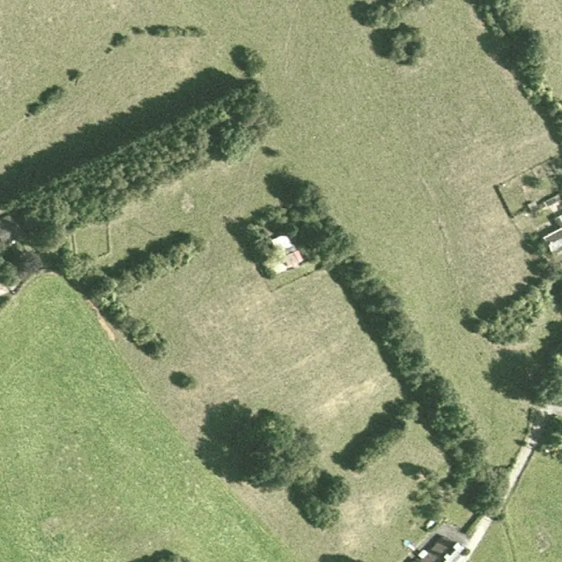 Photo aérienne des années 1990&nbsp;: le toit rouge du chalet entre les arbres